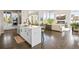 Open concept kitchen with white cabinets and a large island that overlooks living area at 8263 Merryvale Trl, Parker, CO 80138