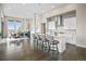 Modern kitchen with white cabinets, large island with seating, and opens to dining area at 8263 Merryvale Trl, Parker, CO 80138