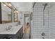 Renovated bathroom featuring double sinks, modern vanity, and a shower/tub at 1185 Xanthia St, Denver, CO 80220