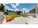Landscaped backyard features a patio with outdoor seating, a grassy area, and a charming play structure at 19000 E 55Th Ave, Denver, CO 80249