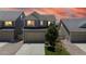 Charming two-story home with a two car garage, landscaped yard, and neutral siding at sunset at 19000 E 55Th Ave, Denver, CO 80249