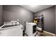 Well-organized laundry room with gray walls, modern washer and dryer, and convenient shelving for storage at 19000 E 55Th Ave, Denver, CO 80249