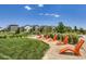 Inviting community green space with modern orange lounge chairs and lush landscaping at 13589 E 102Nd Pl, Commerce City, CO 80022