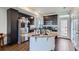 Modern kitchen features stainless steel appliances, granite countertops, kitchen island, and dark cabinets at 13589 E 102Nd Pl, Commerce City, CO 80022