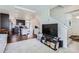 Cozy living room flowing into open kitchen, featuring hardwood floors, plush carpet, and access to stairway at 13589 E 102Nd Pl, Commerce City, CO 80022