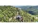 Majestic aerial view of a luxurious house, nestled in a lush forest with distant mountain vistas at 14980 Elk Mountain Trl, Littleton, CO 80127