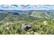 Stunning aerial view of mountain home, nestled in a verdant forest landscape at 14980 Elk Mountain Trl, Littleton, CO 80127