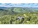 Beautiful aerial view of an elevated home, surrounded by lush forest and mountain scenery at 14980 Elk Mountain Trl, Littleton, CO 80127