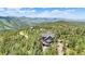 Aerial view of mountain home nestled in a lush forest, showcasing its serene location and charming architecture at 14980 Elk Mountain Trl, Littleton, CO 80127