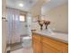 Cozy bathroom featuring a shower-tub combo, wooden vanity, and decorative accents at 14980 Elk Mountain Trl, Littleton, CO 80127