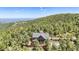 Secluded home exterior surrounded by green trees with large picture window and deck with expansive views at 14980 Elk Mountain Trl, Littleton, CO 80127