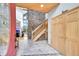 Grand foyer with stone wall, wood staircase, and tile flooring at 14980 Elk Mountain Trl, Littleton, CO 80127