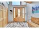 Bright foyer features light wood door, floral rug, and bench seating at 14980 Elk Mountain Trl, Littleton, CO 80127