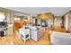 Open-concept living room with a stone fireplace, wood floors, and stainless steel appliances at 14980 Elk Mountain Trl, Littleton, CO 80127