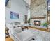 Spacious living room with a stone fireplace, plush seating, and floor-to-ceiling windows at 14980 Elk Mountain Trl, Littleton, CO 80127