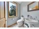 Clean powder room with a vessel sink, modern toilet, and a scenic window offering outdoor views at 14980 Elk Mountain Trl, Littleton, CO 80127