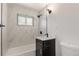 Modern bathroom featuring marble tile in shower and vanity with dark hardware at 2702 Atchison St, Aurora, CO 80011