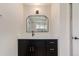 Bathroom vanity with dark wood cabinets, white countertop, and arched mirror with modern lighting at 2702 Atchison St, Aurora, CO 80011