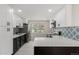 Modern kitchen showcasing white cabinets, black hardware, a black island, and updated stainless appliances at 2702 Atchison St, Aurora, CO 80011
