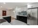 Contemporary kitchen featuring black and white cabinets, stainless steel appliances, and modern backsplash at 2702 Atchison St, Aurora, CO 80011