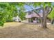 Backyard view shows home exterior with balcony, patio and mature tree at 2122 S Yank Way, Lakewood, CO 80228