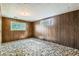 Basement bedroom features wood paneled walls and two windows for natural light at 2122 S Yank Way, Lakewood, CO 80228