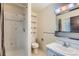 Tiled bathroom features a shower and vanity with a large mirror and built-in shelving at 2122 S Yank Way, Lakewood, CO 80228
