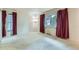 Spacious bedroom with two windows and red curtains with white carpet at 2122 S Yank Way, Lakewood, CO 80228