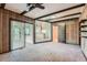 Cozy living room features wooden panels and ceiling beams with sliding door to a sunroom at 2122 S Yank Way, Lakewood, CO 80228