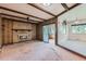 Cozy living room features a brick fireplace, wood paneling, and exposed beam ceiling at 2122 S Yank Way, Lakewood, CO 80228