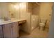 Well-lit bathroom featuring wood-toned cabinets, a walk-in bathtub, and tiled walls at 3131 E Alameda Ave # 1604, Denver, CO 80209