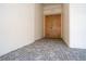Condo entrance with neutral carpet; features solid wood door with modern hardware and unit number at 3131 E Alameda Ave # 1604, Denver, CO 80209