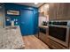 Modern kitchen with stainless steel appliances, granite countertops, custom cabinets, and stylish blue door at 3131 E Alameda Ave # 1604, Denver, CO 80209