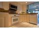 Bright kitchen with white appliances, granite countertops and backsplash, and ceramic tile flooring at 3131 E Alameda Ave # 1604, Denver, CO 80209