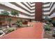 Indoor atrium in a highrise featuring lush landscaping, red stone walkways, and bench seating at 3131 E Alameda Ave # 1604, Denver, CO 80209