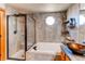 Modern bathroom with glass-enclosed shower, soaking tub, and decorative shelving for added storage at 1678 S Parkdale Cir, Erie, CO 80516