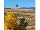A hot air balloon floats gracefully over a picturesque landscape with mountain views at 1678 S Parkdale Cir, Erie, CO 80516