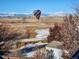 A rainbow-colored hot air balloon soars over a snowy landscape with stunning mountain vistas at 1678 S Parkdale Cir, Erie, CO 80516