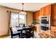Bright eat-in kitchen features stainless steel appliances, wood cabinets, granite counters, and sliding glass door to deck at 1678 S Parkdale Cir, Erie, CO 80516