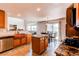 Open concept kitchen with island, stainless appliances, tile backsplash, copper farmhouse sink, and a cozy breakfast nook at 1678 S Parkdale Cir, Erie, CO 80516