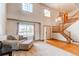 Elegant living room with high ceilings, large windows, hardwood floors, and a staircase at 1678 S Parkdale Cir, Erie, CO 80516