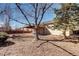 Large backyard with a covered patio, mature trees, and a fire pit area at 152 Pelican Ave, Brighton, CO 80601