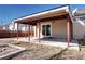 Covered patio in the backyard with wood supports, concrete flooring, and a sliding glass door at 152 Pelican Ave, Brighton, CO 80601