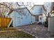 View of the home's exterior from the backyard featuring a stone patio and fenced yard at 2550 Xanthia Ct, Denver, CO 80238