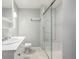 Bathroom featuring a modern glass shower, single vanity sink, and a white tiled floor at 2550 Xanthia Ct, Denver, CO 80238