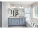 Bright bathroom with dual sink vanity, granite countertops, and a large soaking tub next to the window at 2550 Xanthia Ct, Denver, CO 80238
