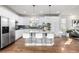 Well-lit kitchen featuring an island with seating, stainless steel appliances, and hardwood floors at 2550 Xanthia Ct, Denver, CO 80238