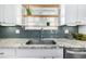 Detailed view of a kitchen sink area with granite countertops and tiled backsplash at 2550 Xanthia Ct, Denver, CO 80238