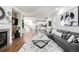 Open-concept living room featuring hardwood floors, contemporary furnishings, and a view into the kitchen at 2550 Xanthia Ct, Denver, CO 80238