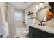 Stylish bathroom with a deep green vanity, round mirror, and tiled shower for a spa-like experience at 2001 Grove St, Denver, CO 80211